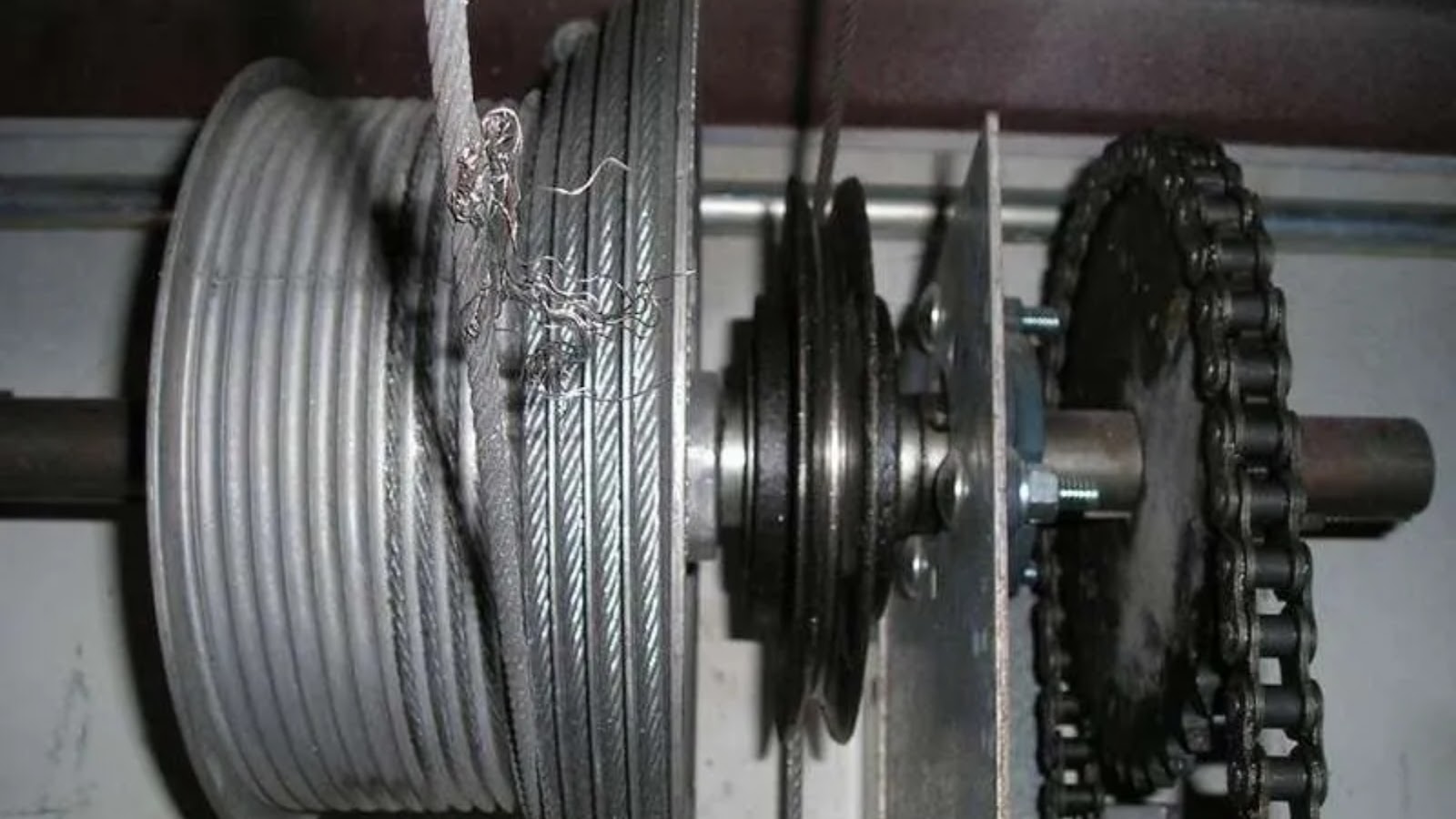 A frayed cable wound in its garage door cable drum