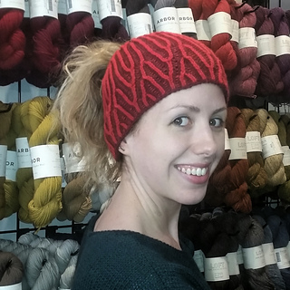 woman wearing a brioche knit messy bun hat in yarn store