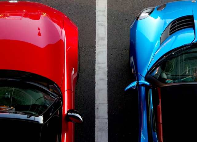 a shot of stylish red and blue cars parked next to each other