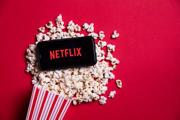 LONDON, UK - MAY 14 2020: Netflix logo on a smartphone with popcorn