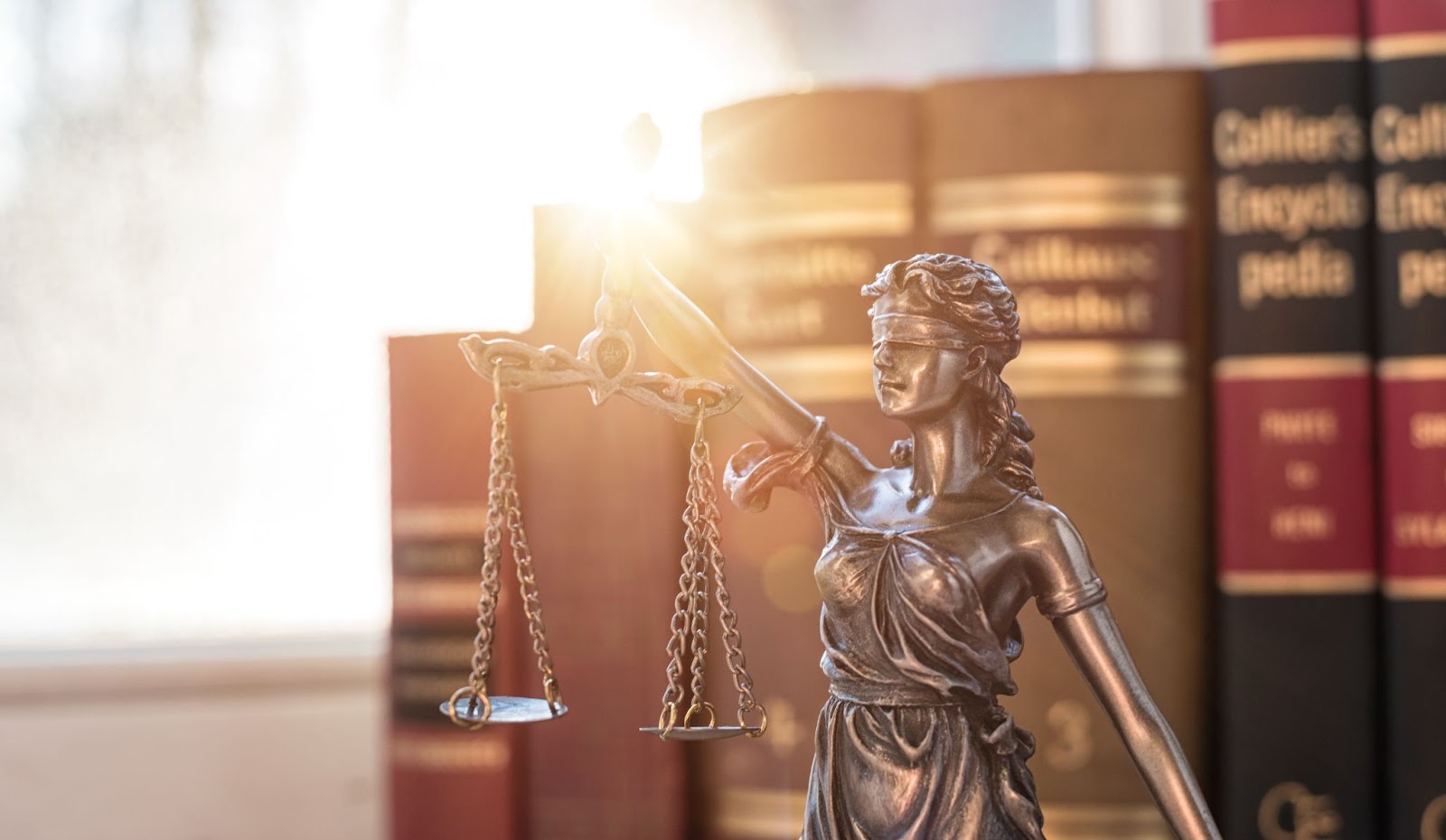 "Lady justice statue in front of law books"