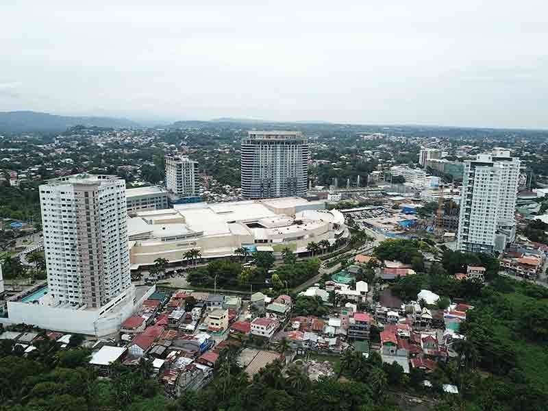 A view of the city, with several tall buildings and houses all around.