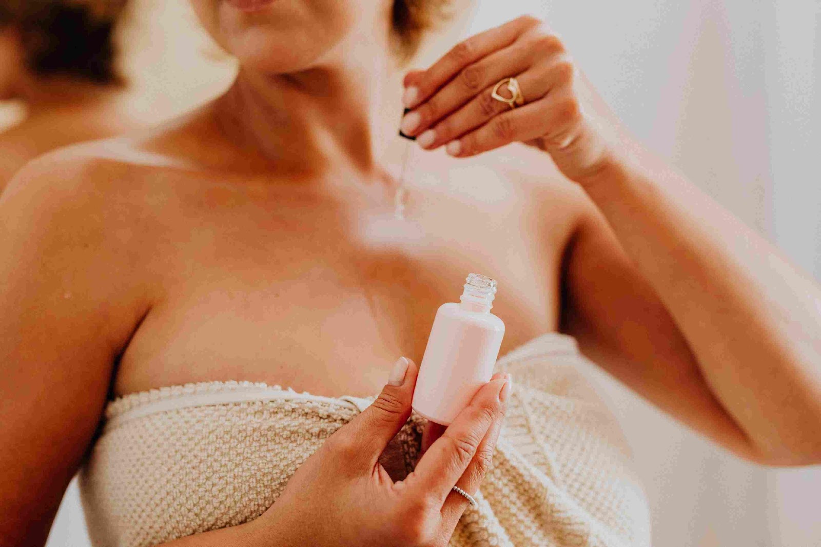 A person applying a bottle of perfume

Description automatically generated