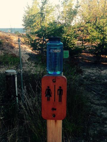 A full water bottle and a sign for a bathroom were rare along the backpacking trail in Pictured Rocks. 