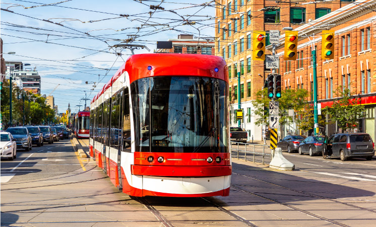 A city cable car travels through downtown Toronto on a sunny day.