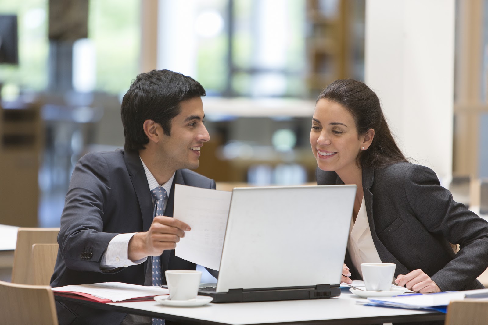 Imagem frontal de um homem e uma mulher observando uma tela de notebook. Seu objetivo é ilustrar o envolvimento dos recursos humanos quando se escolhe migrar para nuvem.