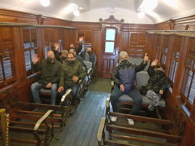 El grup visitant assegut dins el vagó del tren antic