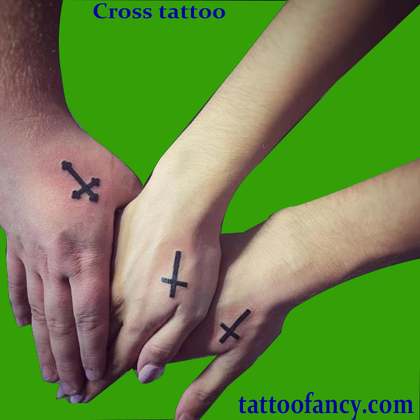 Cross tattoo between thumb and index finger