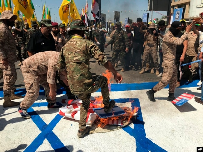 Сили народної мобілізації Іраку спалюють прапори США та Ізраїлю під час дня «аль-Кудс» (арабською мовою Єрусалим) у Багдаді. Ірак, 31 травня 2019 року