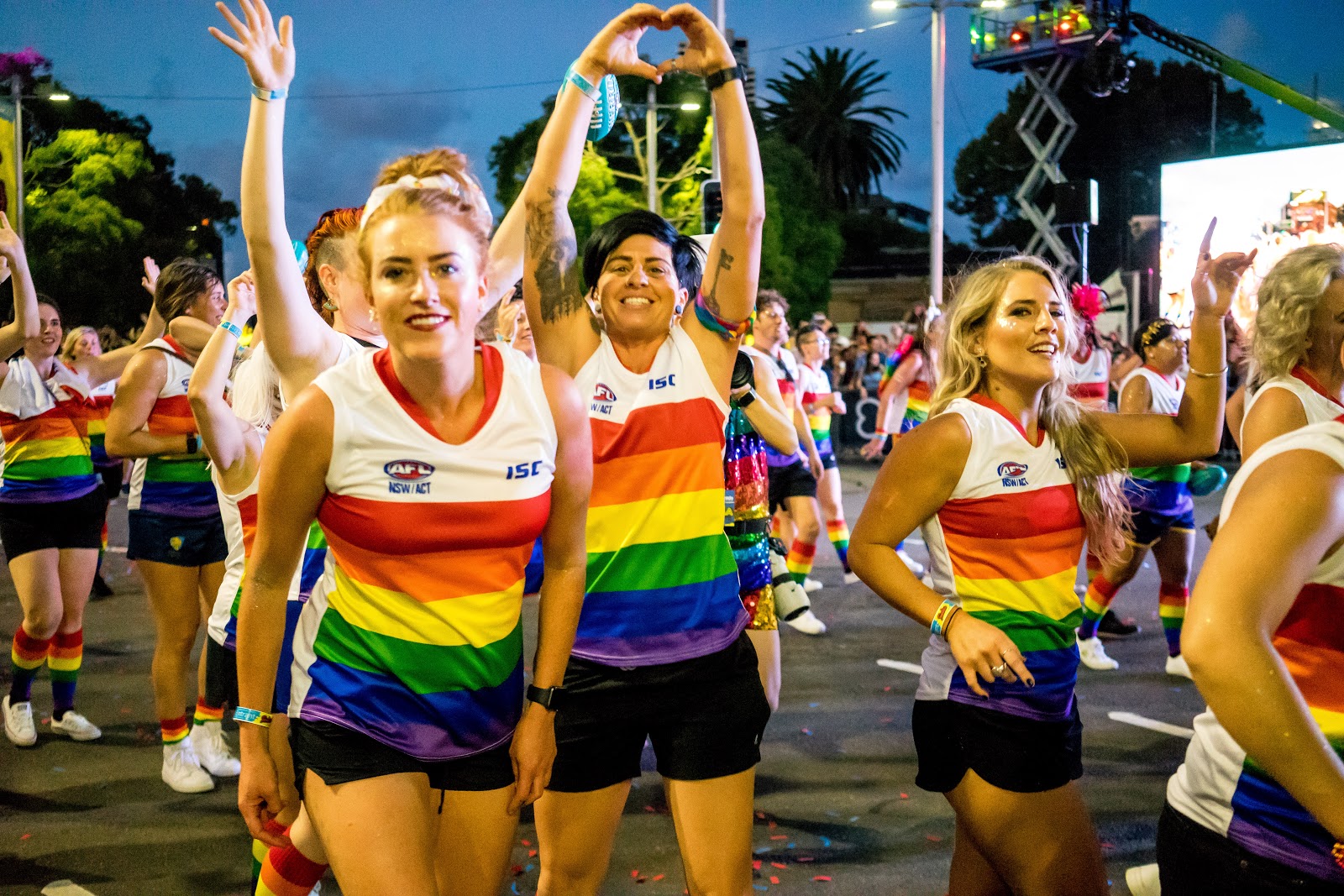 Photo of Mardi Gras parade attendees in colourful AFL uniform