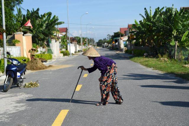 Phụ nữ lớn tuổi băng qua đường ở Hà Tĩnh