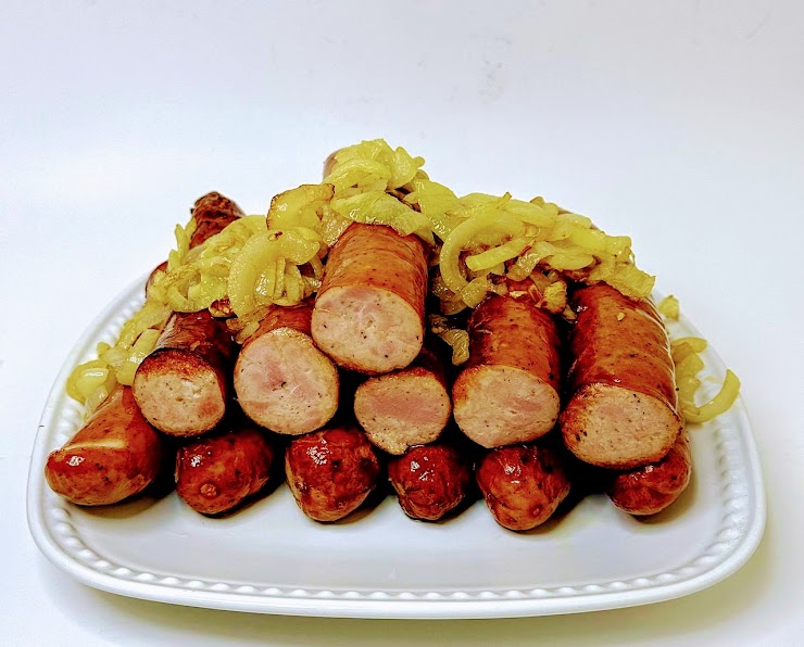 The photo depicts an example of serving, showcasing 12 pieces of fried sausages with fried onion