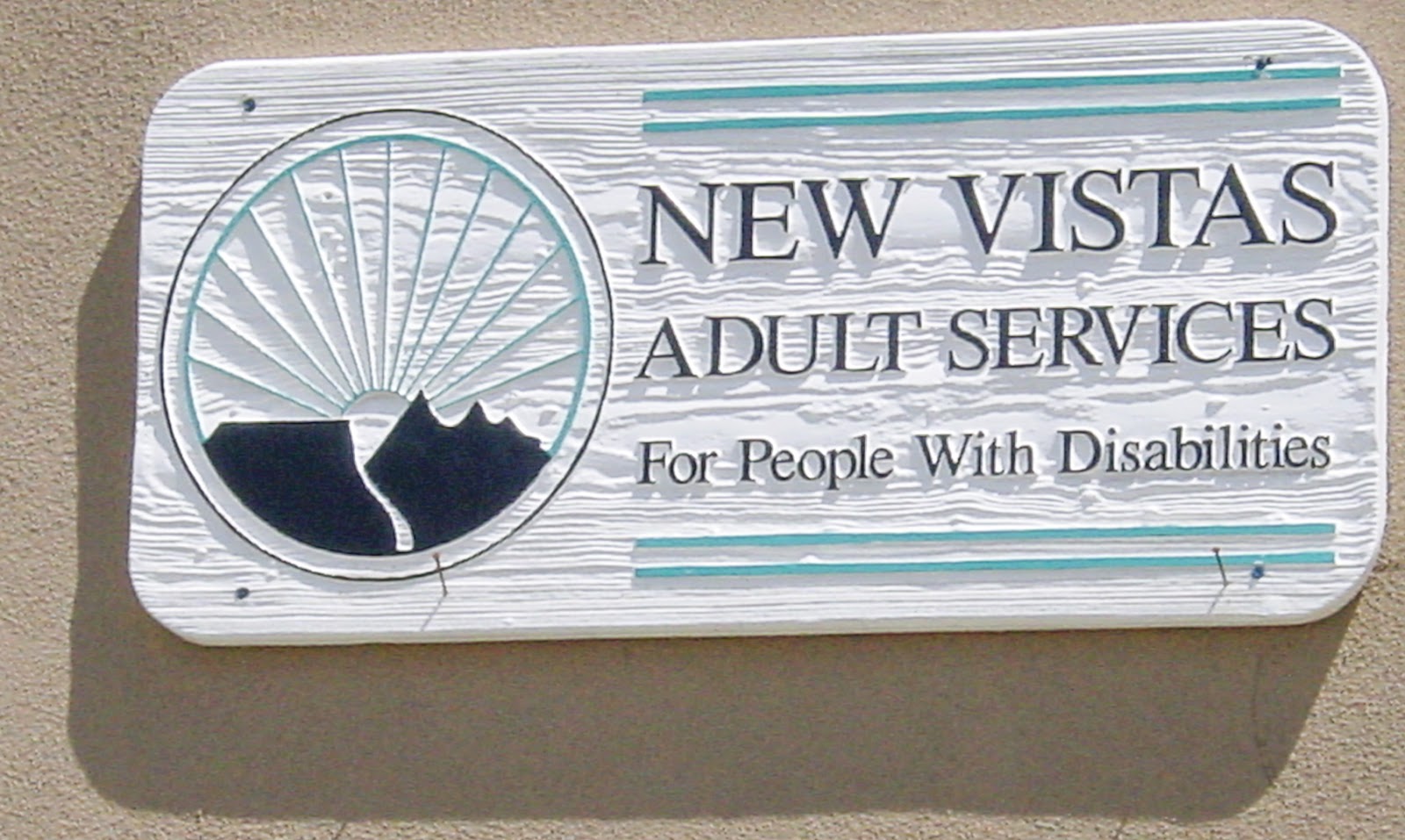Sign with logo of a mountain sunrise: NEW VISTAS ADULT SERVICES For People With Disabilities.