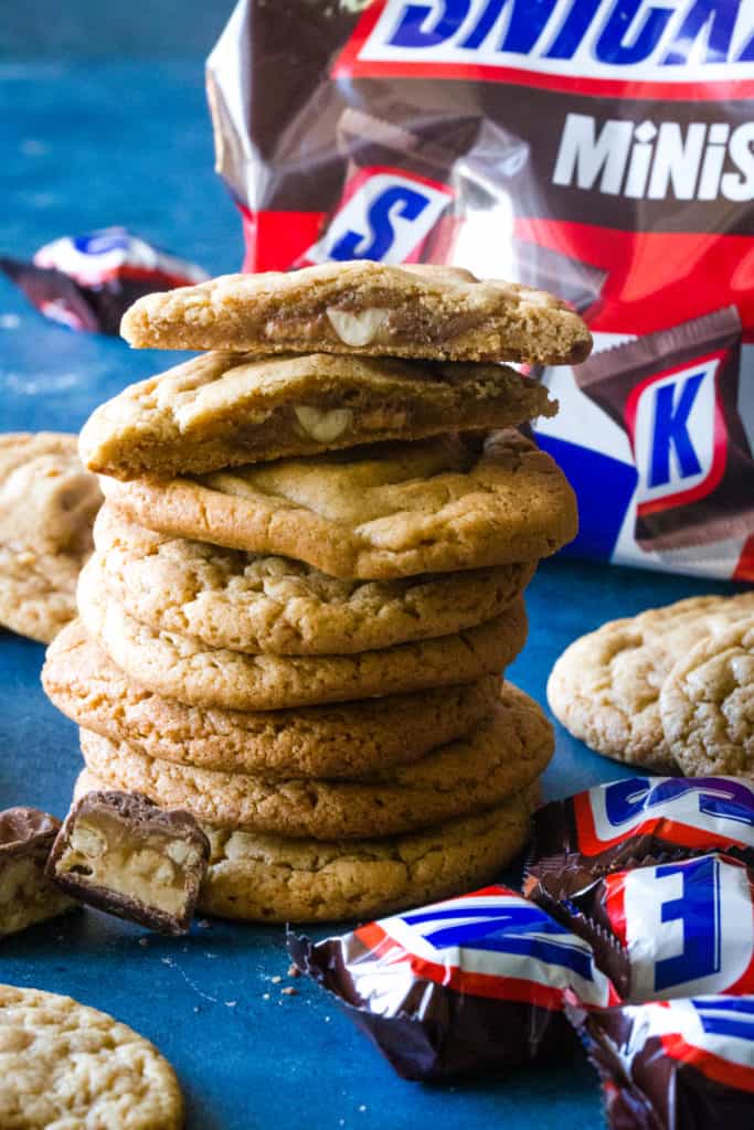 stacked snickers stuffed peanut butter cookies with top cookie cut in half