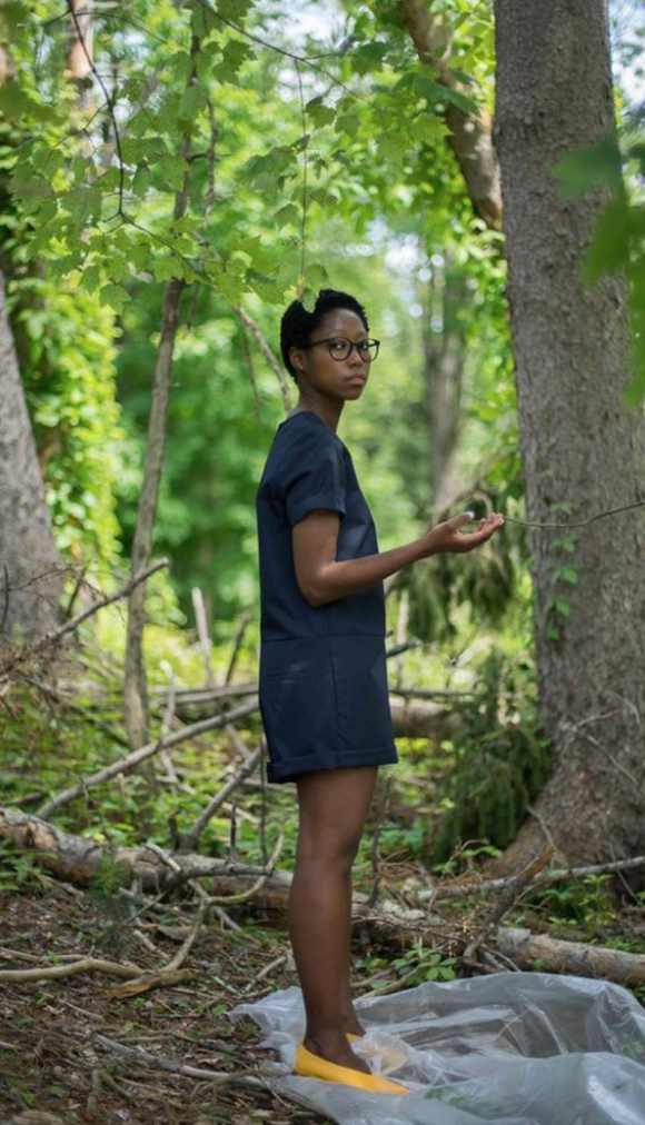 A person standing next to a forestDescription automatically generated