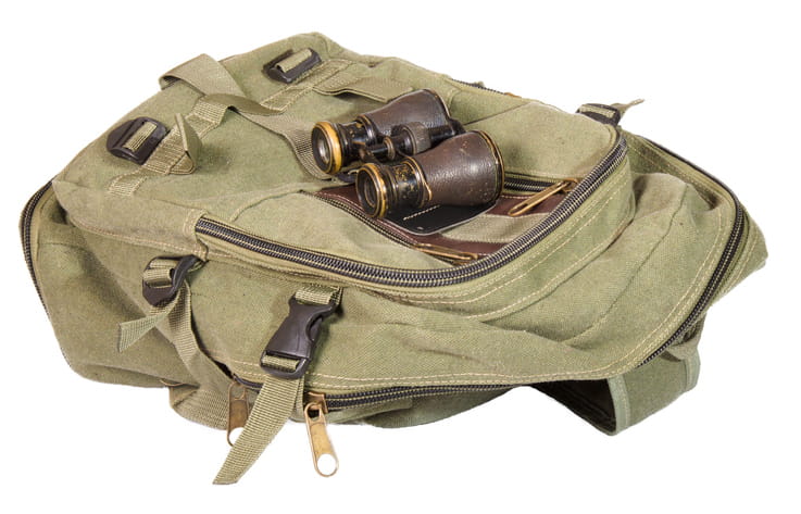 a photo of a tan backpack with binoculars on top