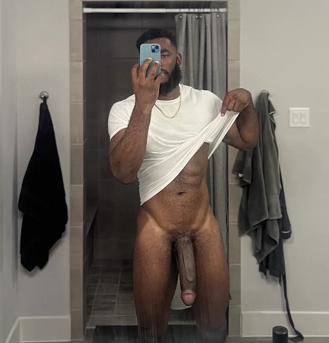 Marshall Price wearing and lifting up his white t-shirt posing for a bathroom mirror selfie wearing no pants and his fat long circumcised penis visible
