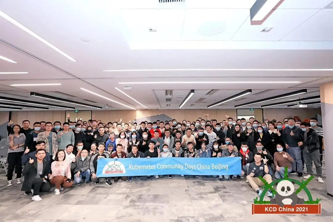 Participants of Kubernetes Community Days posing to camera with KCD China Beijing banner