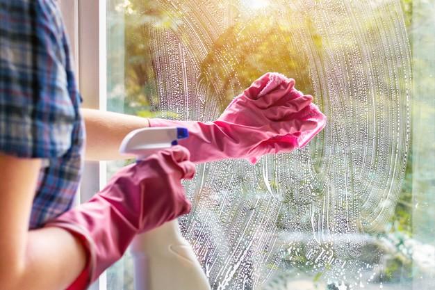 WeServe as one of home maintenance projects to do is cleaning the window with pink gloves, a sponge, and a disinfectant.