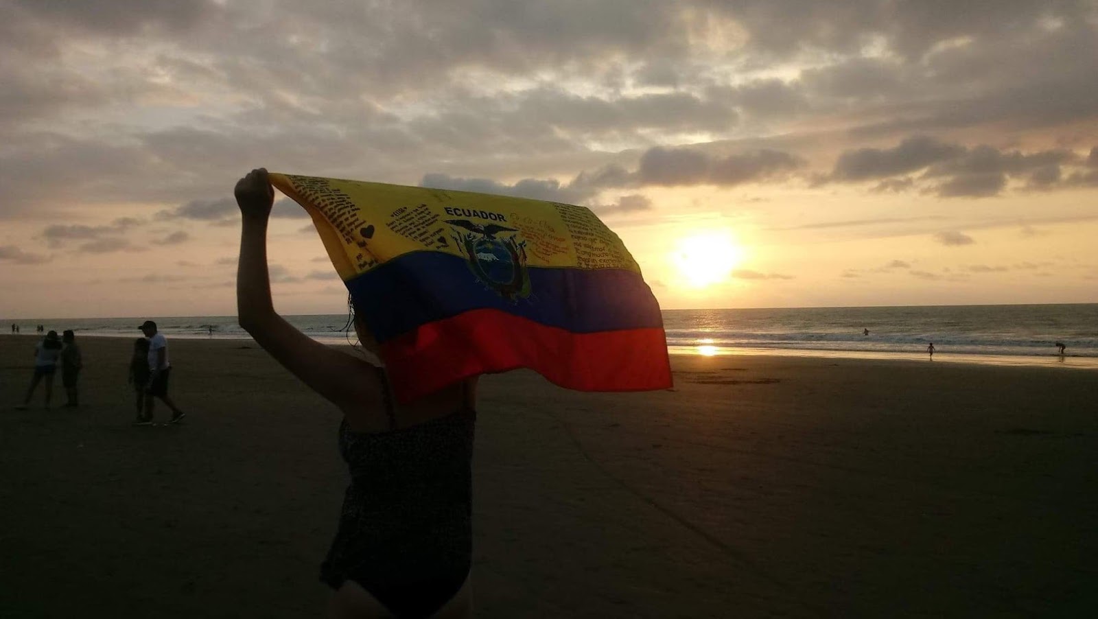 girl with Ecuador flag and sunset behind