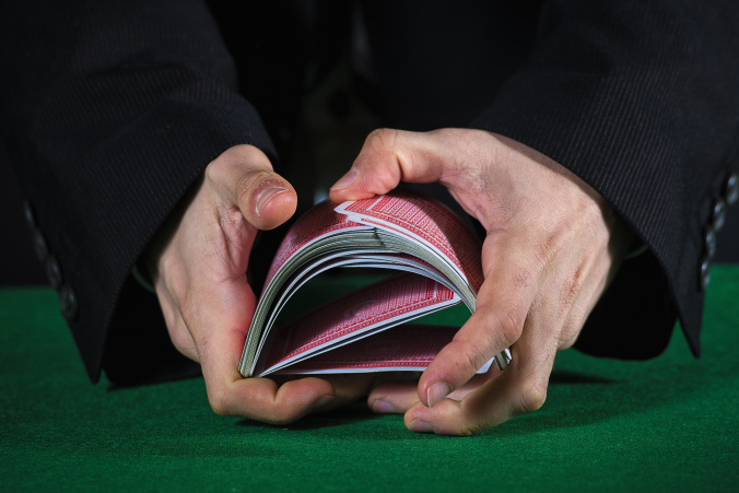Closeup of hands shuffling cards casino
