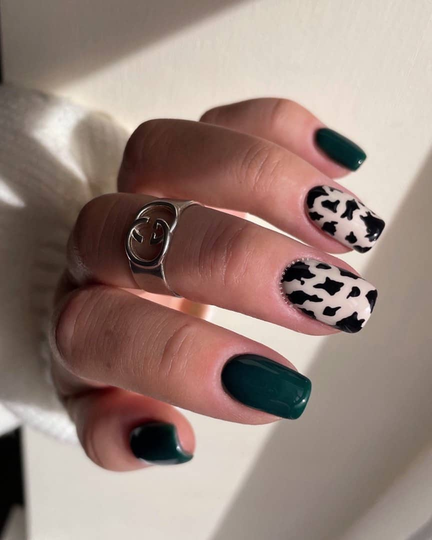 Full picture of a lady rocking her green nails with cow print combo