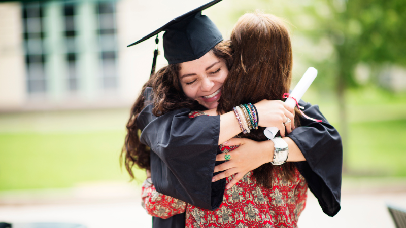 Girl hugging mom at graduation