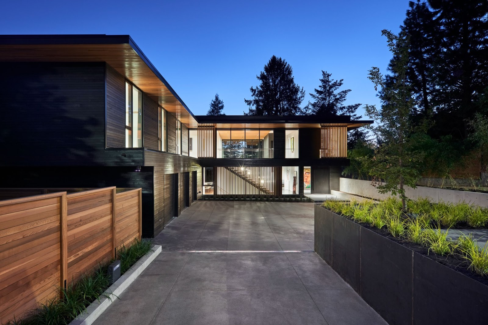 nighttime shot of a recently built beautiful modern home with black walls