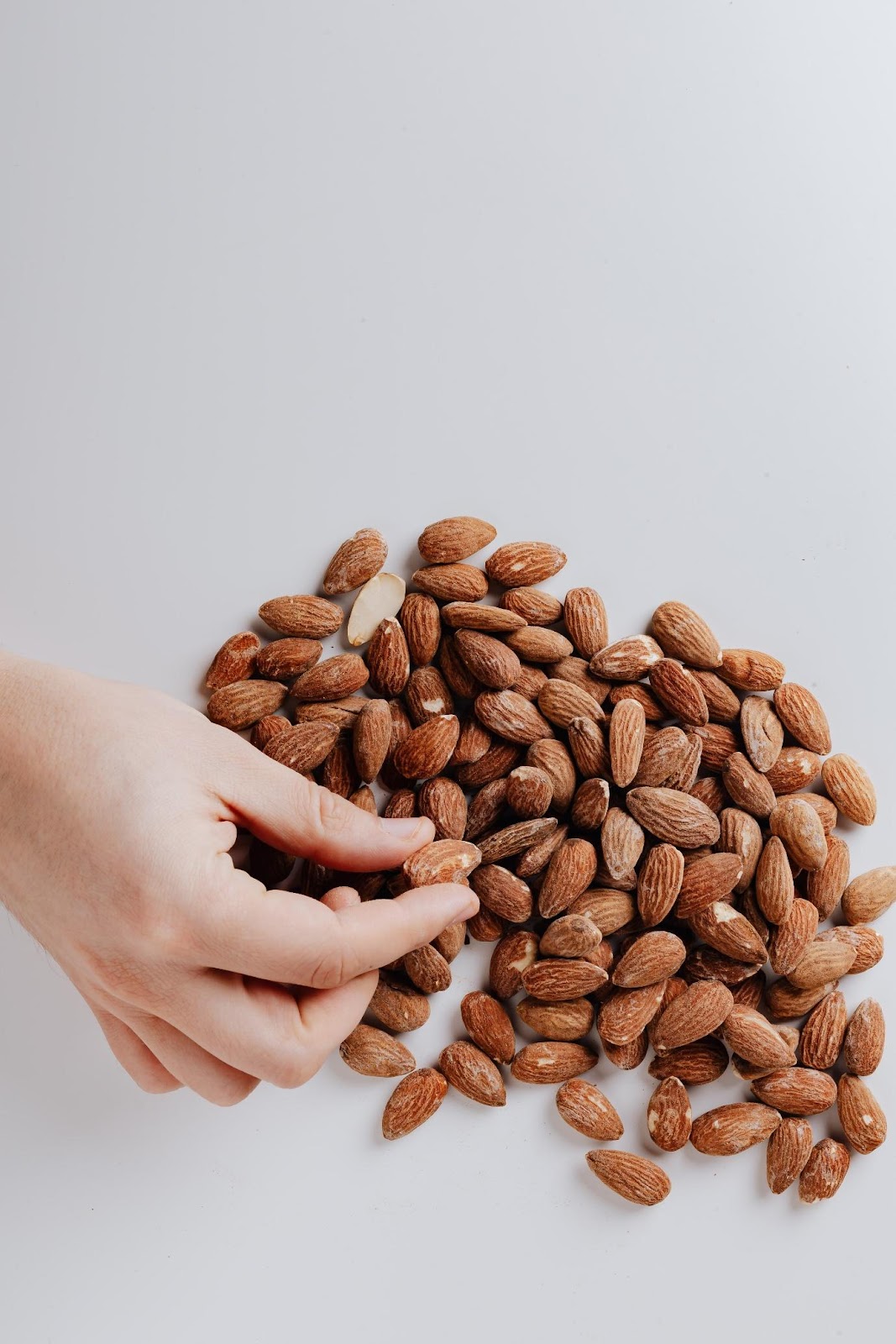 A person holding a handful of coffee beans  Description automatically generated with medium confidence