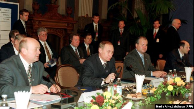 (Слева направо) министр финансов России Михаил Фрадков, премьер-министр Владимир Путин и члены делегации Василий Лихачев и Владимир Рушайло сидят за столом переговоров во время саммита Россия-ЕС в Хельсинки, 22 октября 1999 года