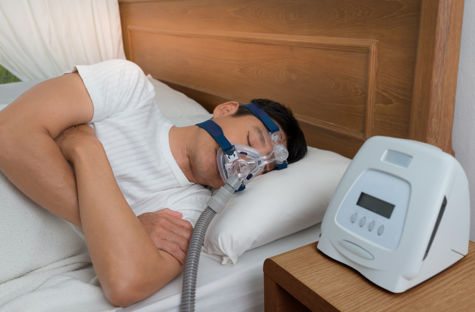 A man sleeping with a CPAP machine on to treat sleep apnea