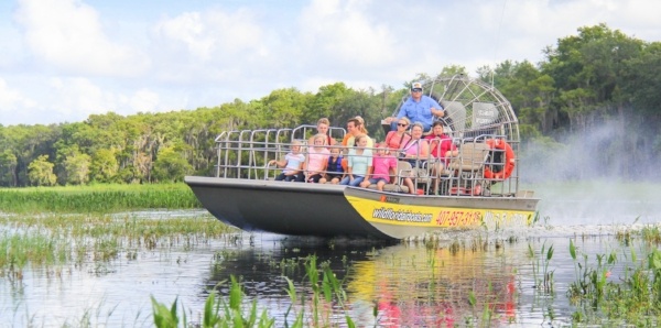 A family enjoys the views of the Florida Everglades as they ride through on an airboat at Wild Florida