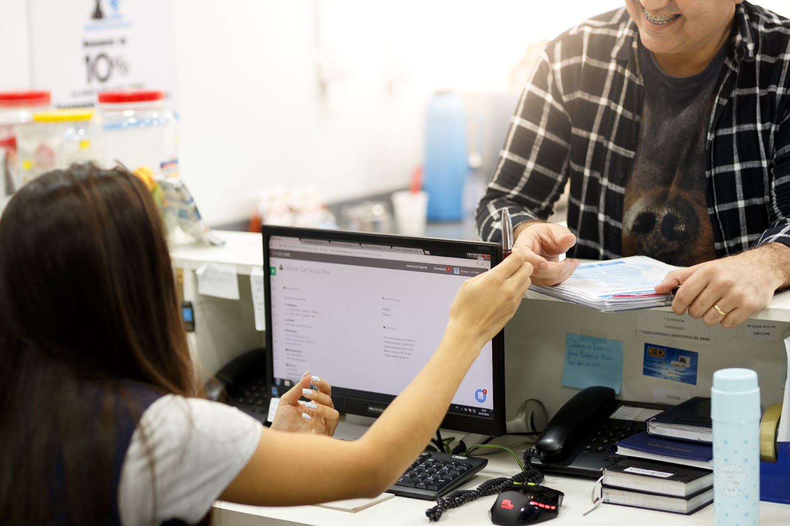 Cliente de pet shop sorrindo interagindo com atendente 