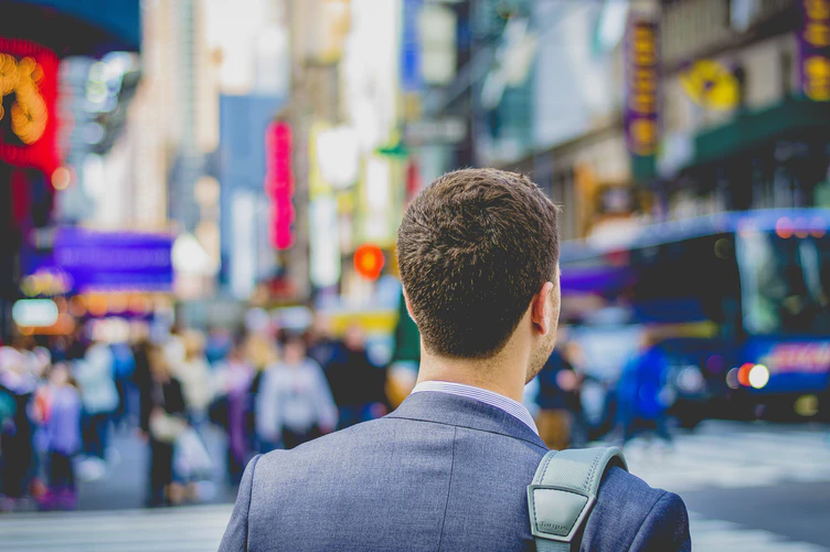 Back of a man’s head in a busy city. 