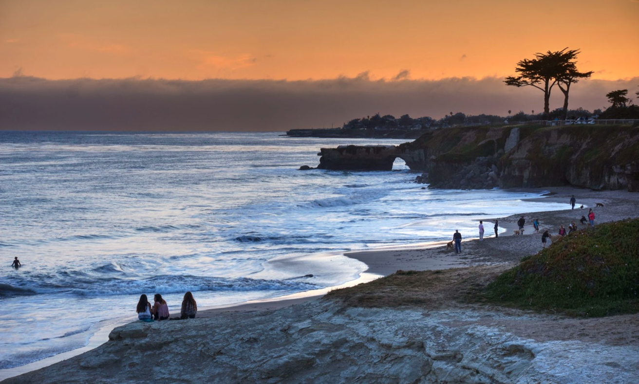 A group of people on a beach</p>
<p>Description automatically generated