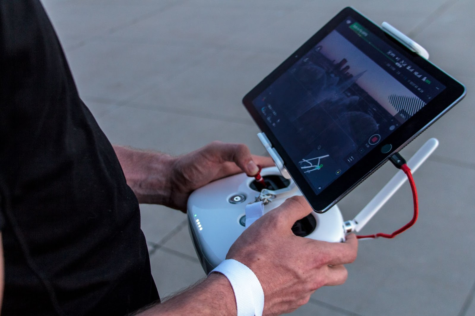 Man controlling a drone through an Ipad