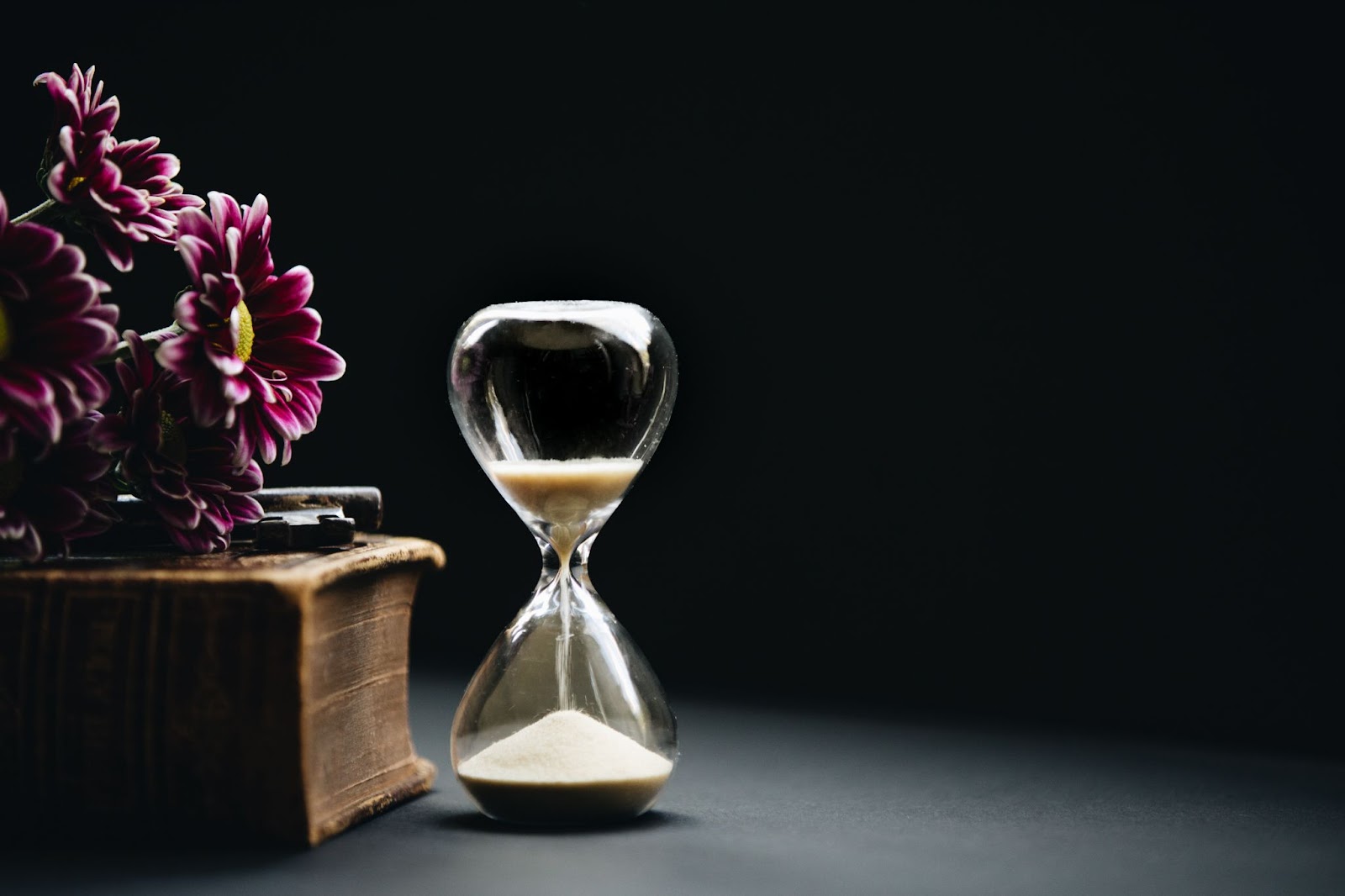 Hourglass next to a bouquet of flowers