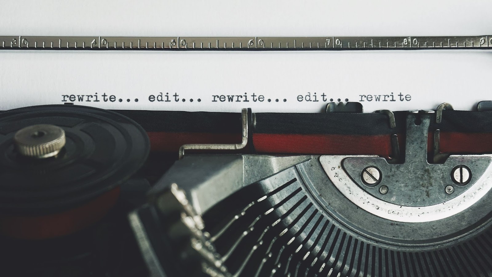 image of paper in typewriter, text reads "rewrite... edit... rewrite... edit..."