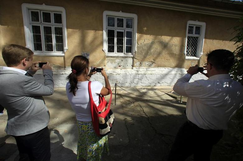 <p>Visitors take pictures of the spot where Romania's late communist dictator Nicolae Ceausescu and his wife Elena were executed on Christmas Day in 1989, at a former military barracks in Targoviste, about 75 km (47 miles) northwest of Bucharest September 3, 2013. The former cavalry barracks, used during the communist era as a military headquarters, has been transformed into a museum and opened to the public. REUTERS/Radu Sigheti</p>
