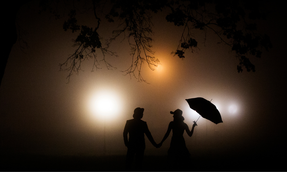 couple in the glommy dark with an umbrella 