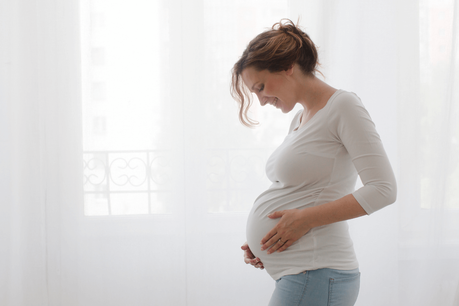 Pregnant woman embracing her belly