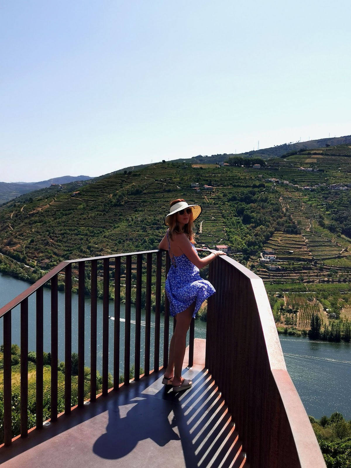 A girl posing on a stand overlooking a multiple wineries