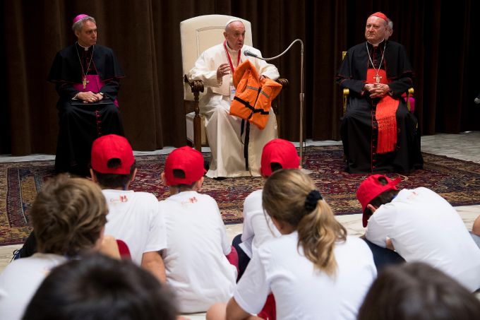 Pope Francis holds the life-jacket of the drowned refugee girl during his remarks to youth at the Vatican, May 28, 2016. Credit: L'Osservatore Romano.