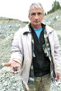 Главный геолог В. Дёмочкин  показывает руду
