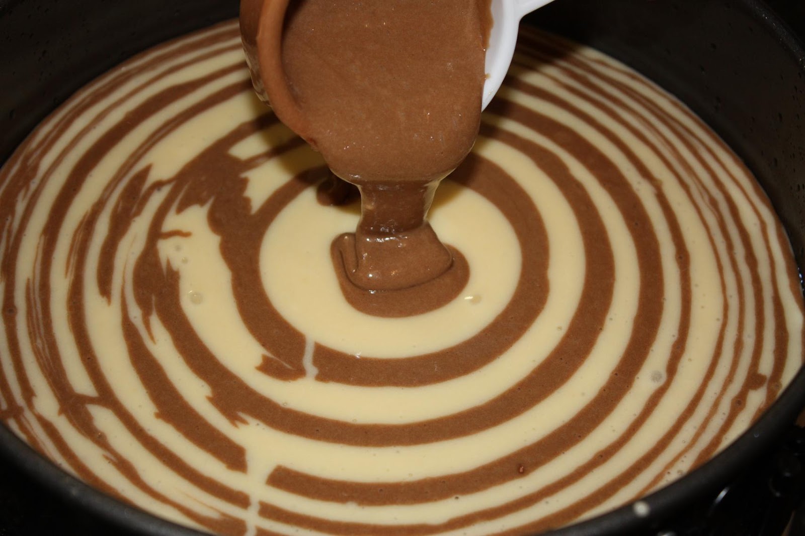 Викладаємо тісто в центр форми, змащеної маслом: спочатку біле, потім шоколадне