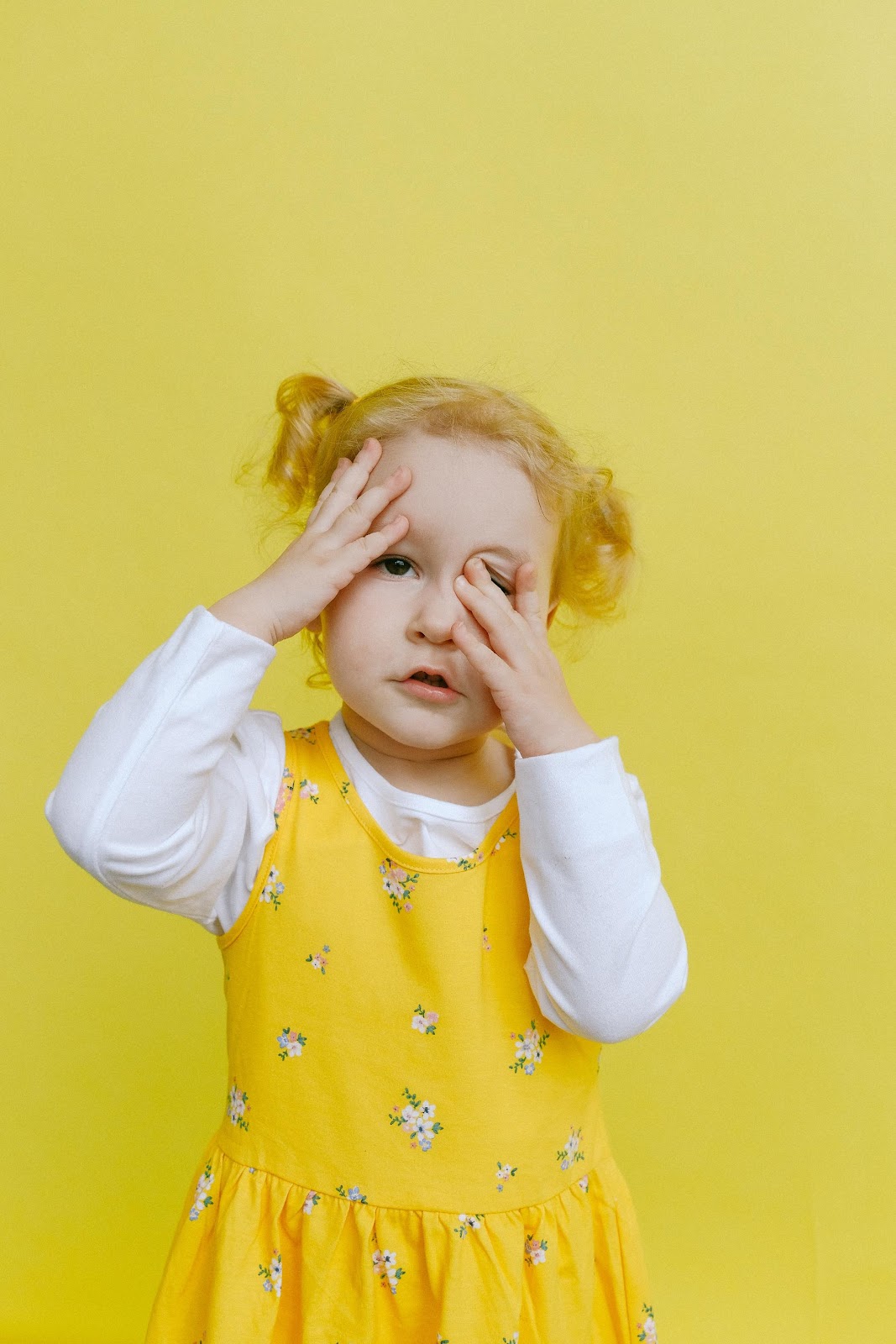 A young girl wearing a yellow dress

Description automatically generated