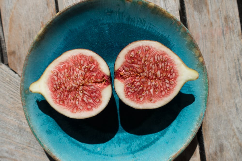 figue coupée en deux sur une assiette bleue