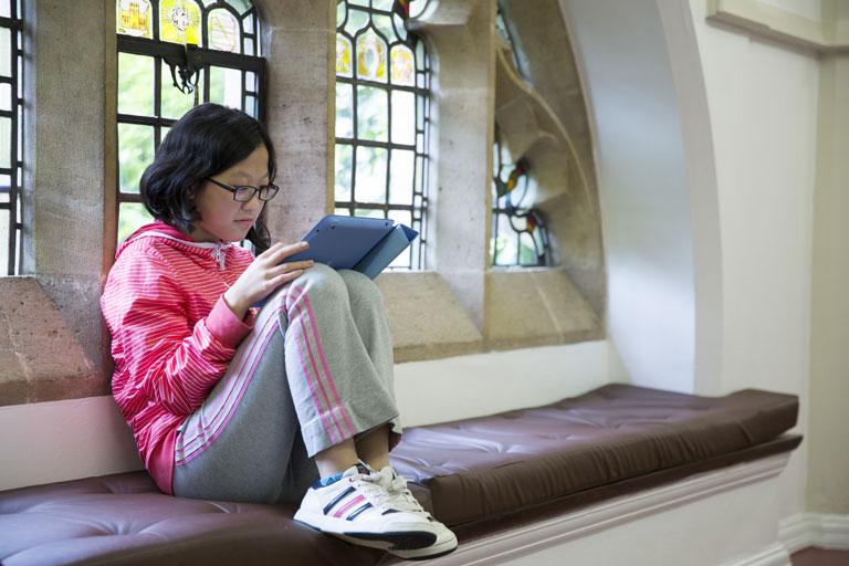 Student reading on a window seat in Bell St Albans