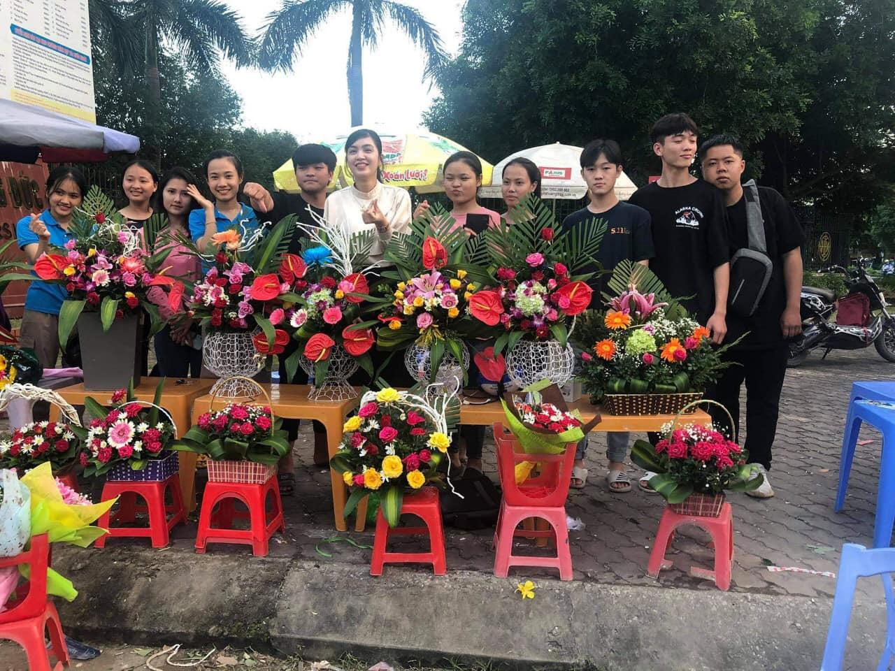 Image may contain: 11 people, people standing, flower and outdoor