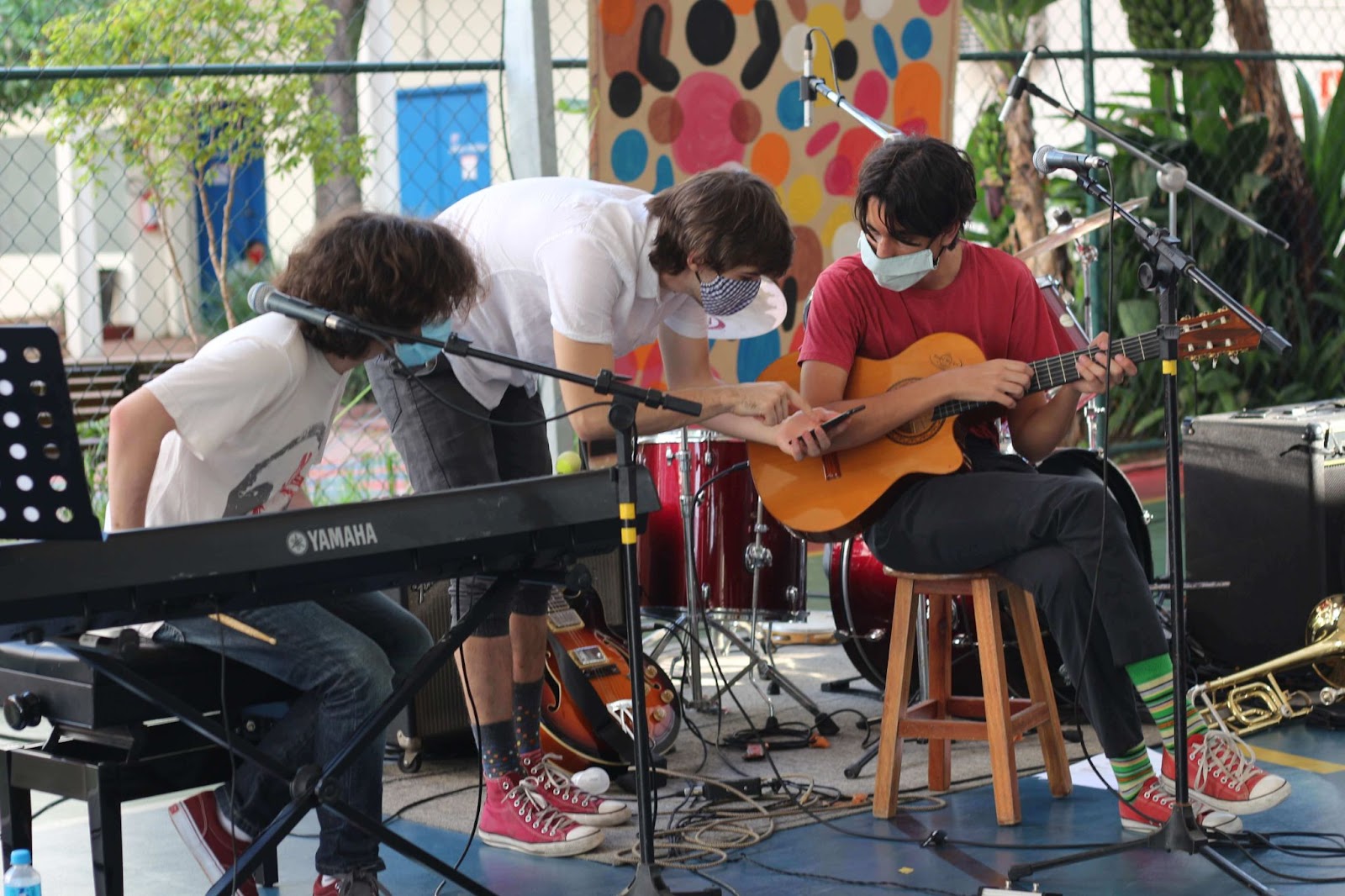 A imagem mostra um grupo de alunos com instrumentos musicais.